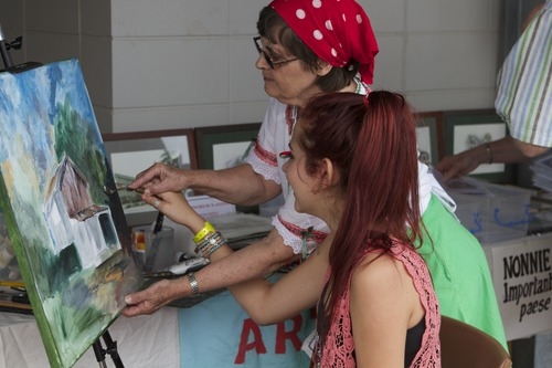 artist-barbara-horsley-involves-chloe-stout-in-adding-a-few-brush-strokes-to-the-old-post-office-at-the-australianitalian-festival-in-ingham-queensland-2013